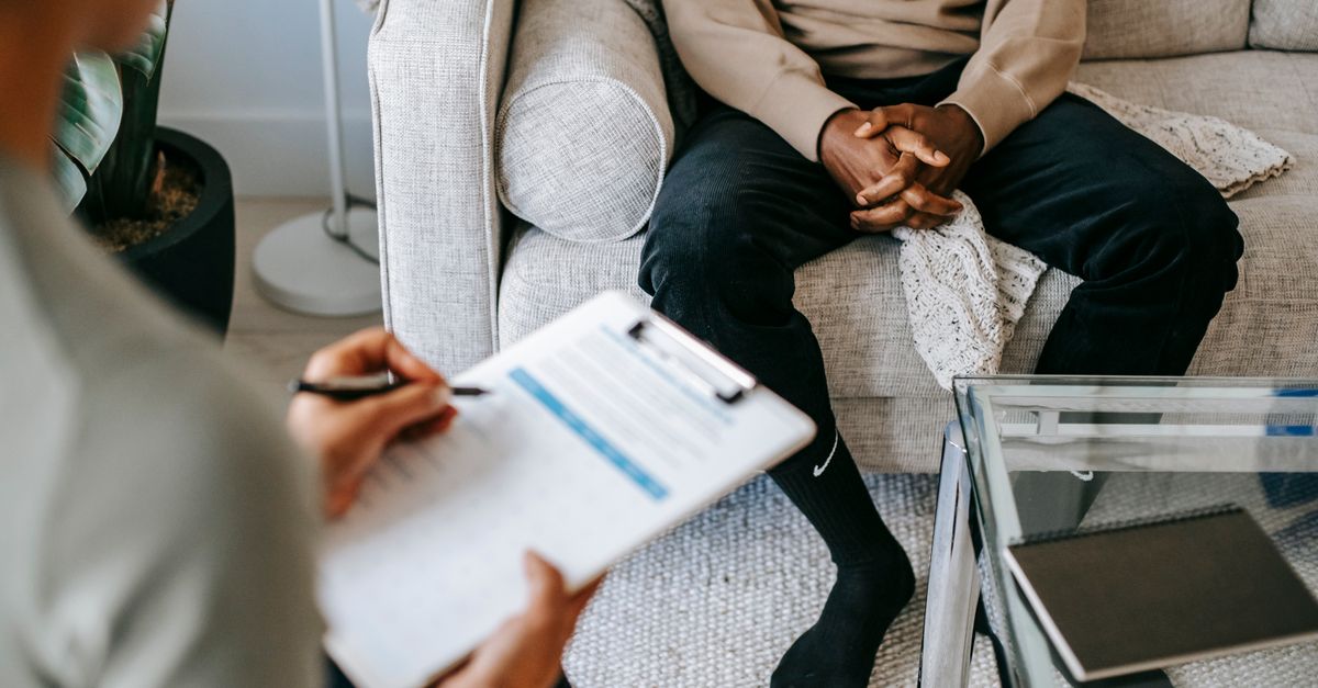 Terapeuta anotando observações durante conversa acolhedora com paciente